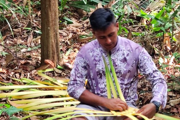Guia fazendo artesanato com folha de palmeira, na selva amazonica